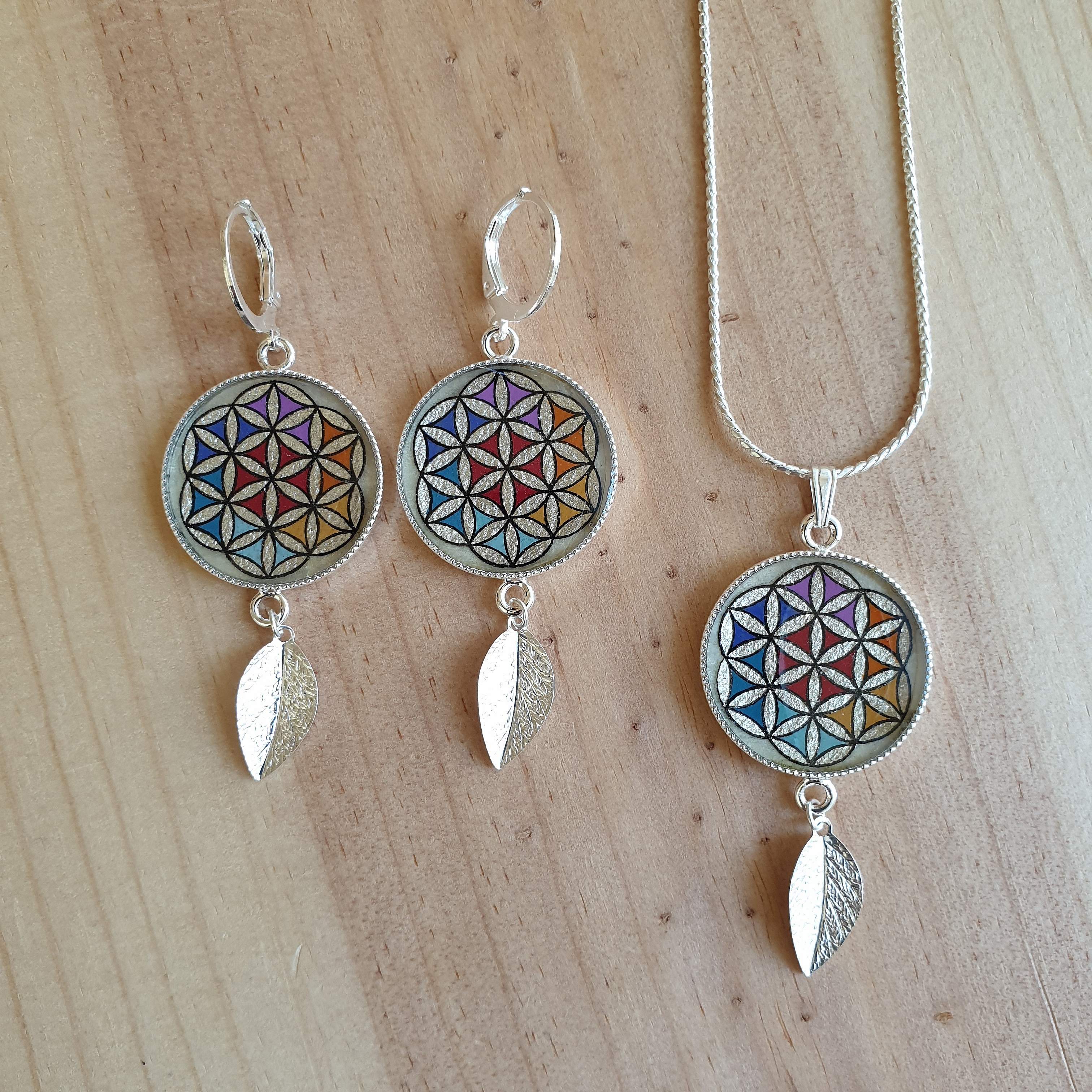 Parure bijoux Fleur de Vie colorée avec feuilles argentées.