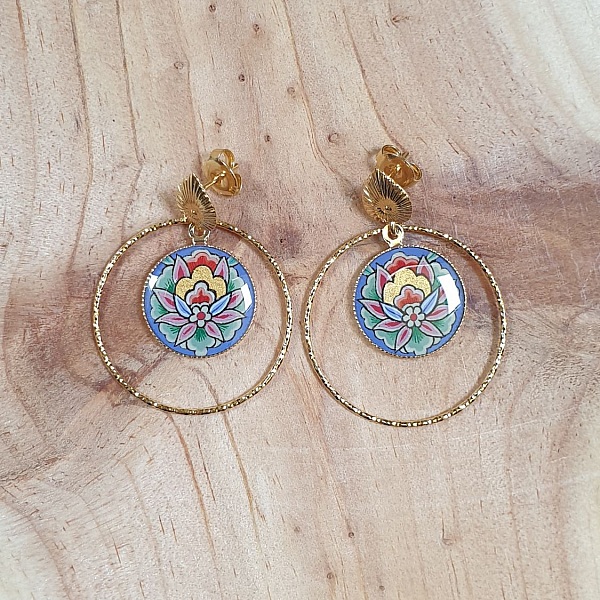 Boucles d'oreilles pendantes fleur orientale sur anneaux dorés.