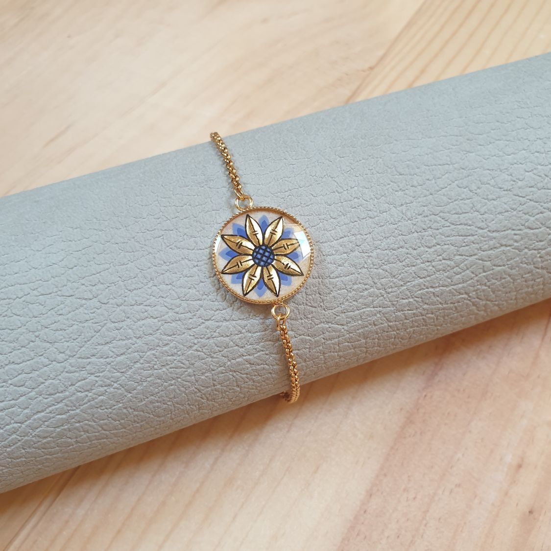 Justerbart armbånd med guld/blåt blomsterdesign på guldkæde