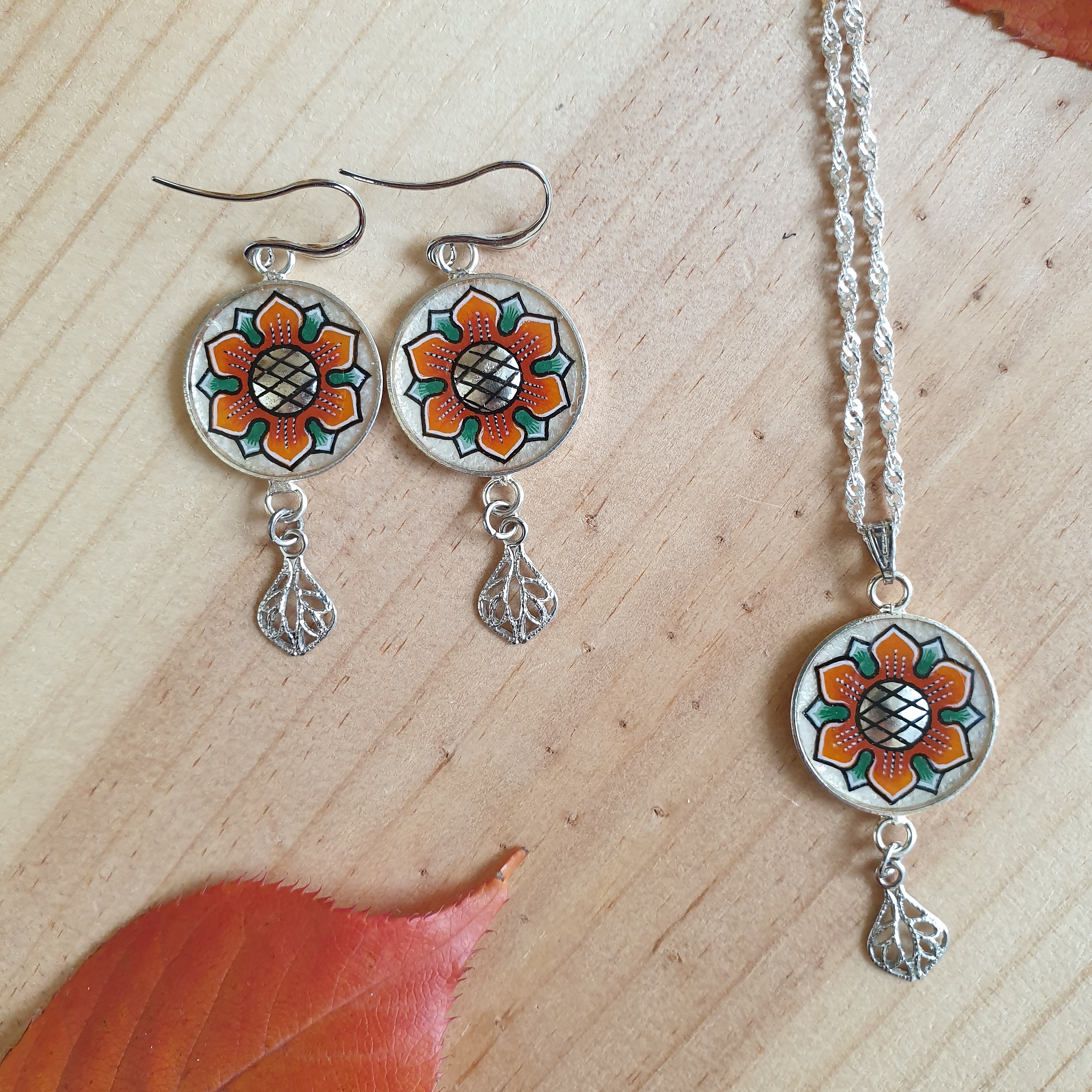 Halsk&aelig;de med orange/guld for&aring;rsblomst vedh&aelig;ng p&aring; s&oslash;lvk&aelig;de