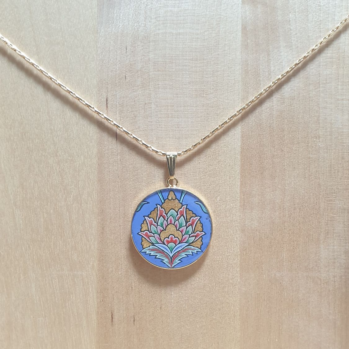 Collier pendentif fleur orientale fond bleu