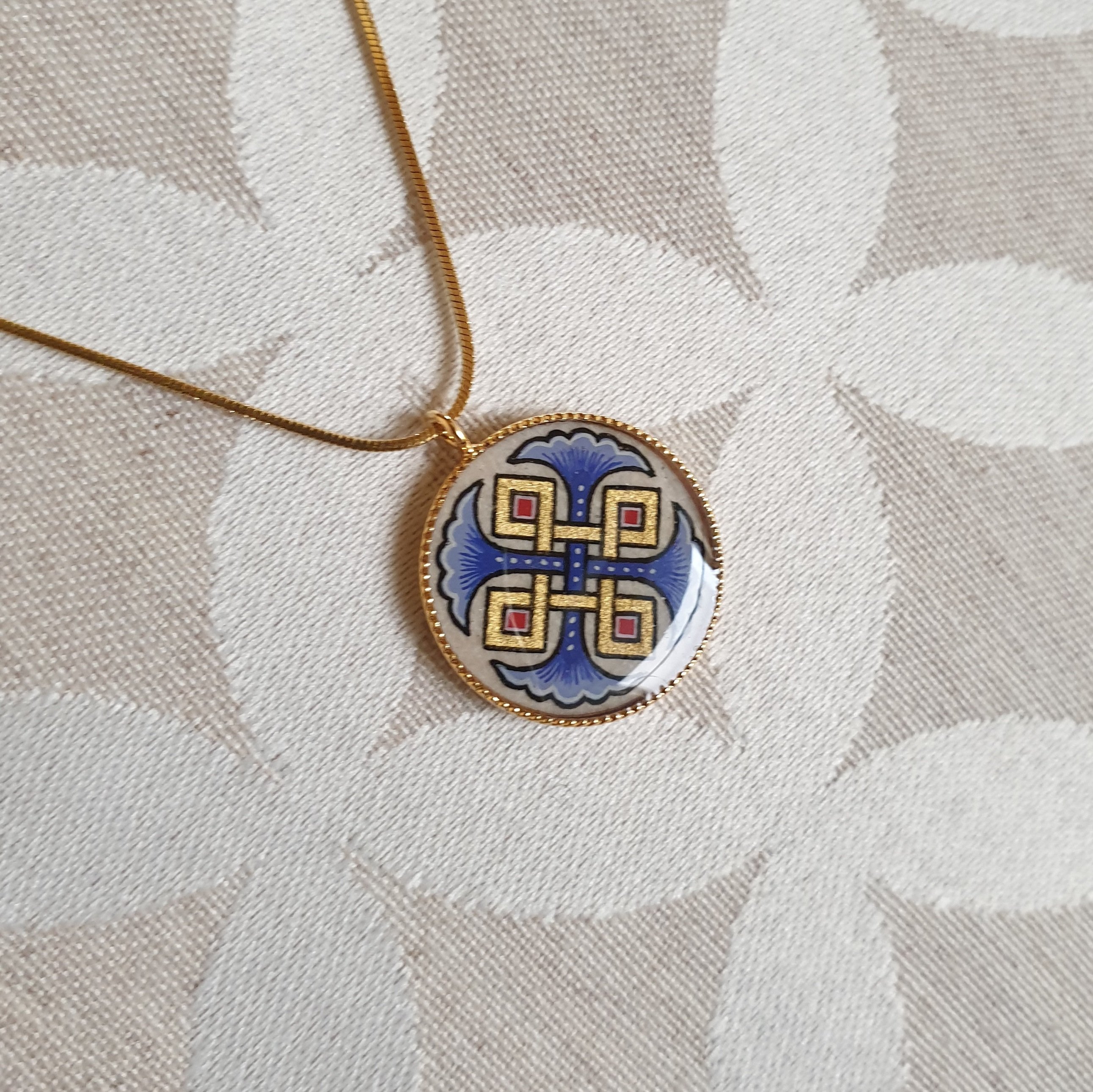 Vedh&aelig;ng halsk&aelig;de med bl&aring; palmetter, guld og r&oslash;de fletninger p&aring; guldk&aelig;de