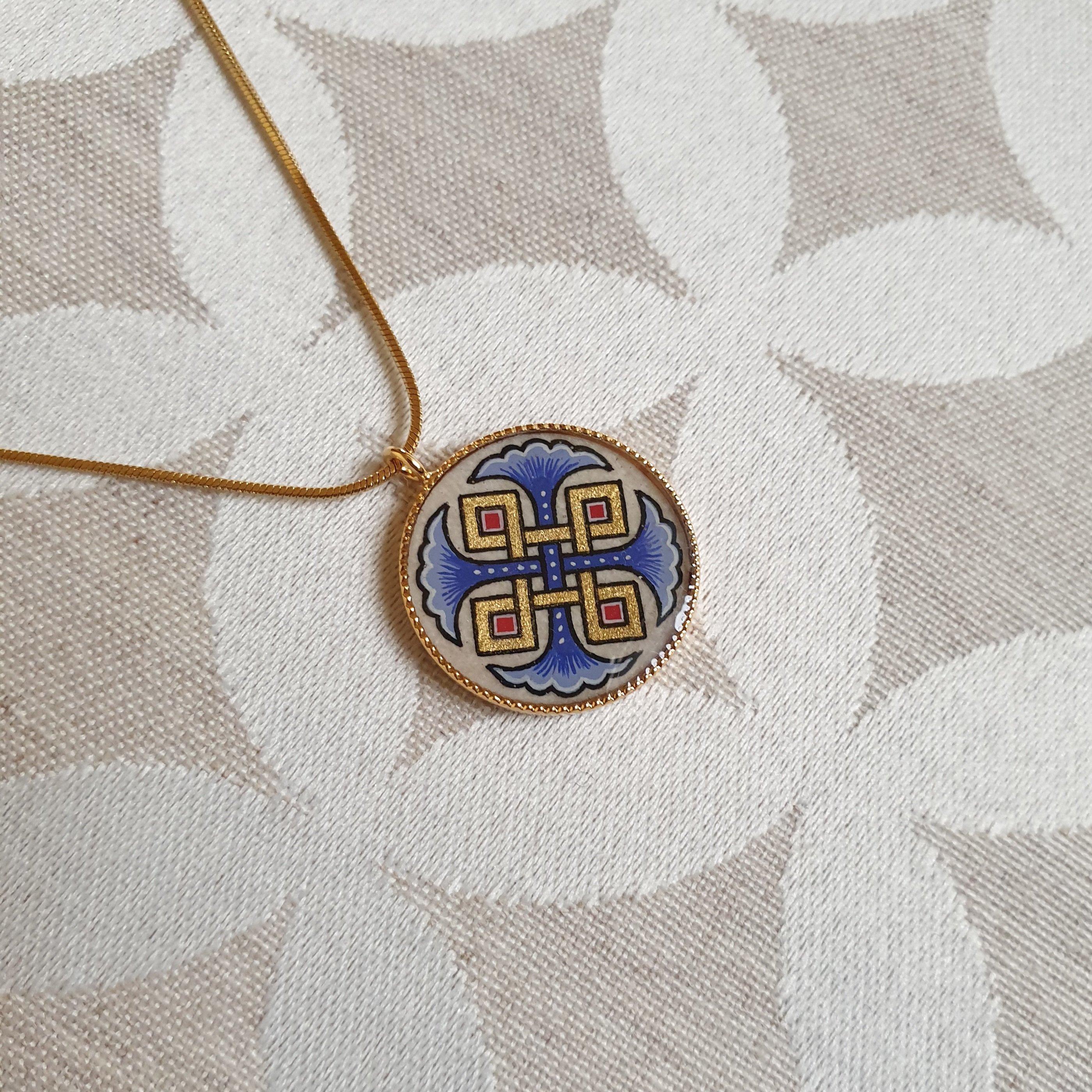 Vedh&aelig;ng halsk&aelig;de med bl&aring; palmetter, guld og r&oslash;de fletninger p&aring; guldk&aelig;de